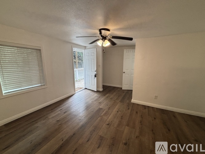 A room with wooden flooring and a ceiling fan.