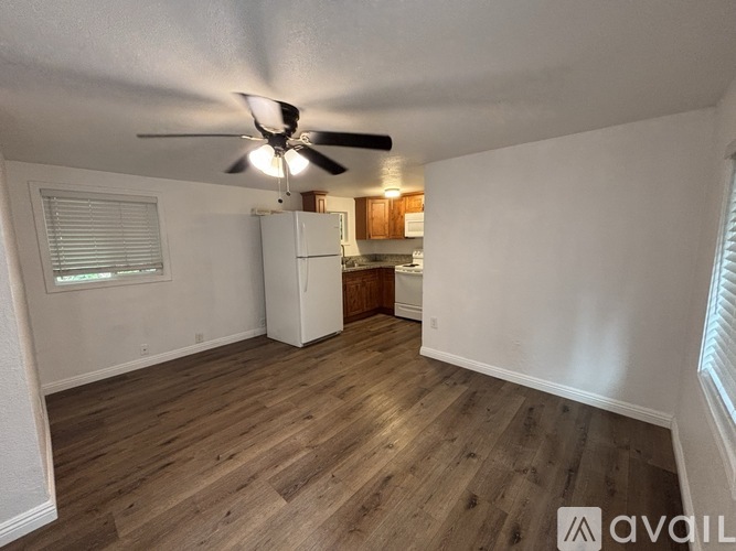 A room with a ceiling fan and wooden flooring.