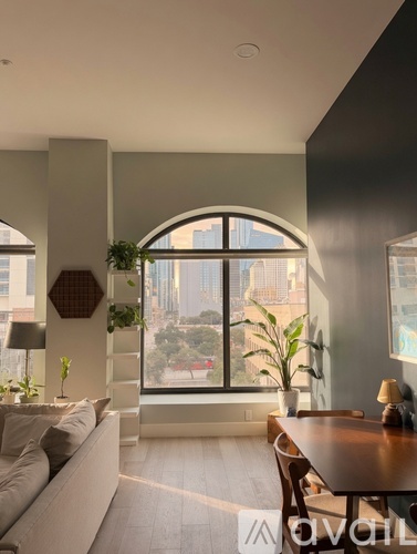 A living room with a large window overlooking a cityscape.
