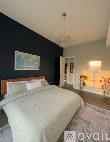 A bedroom with a large bed and a chandelier.