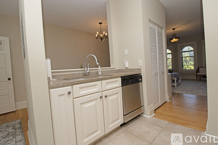 A kitchen with white cabinets and a granite countertop.
