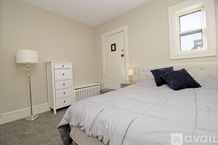 A bedroom with a bed, nightstand, and lamp.