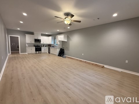 A spacious room with a ceiling fan and lighting fixtures.