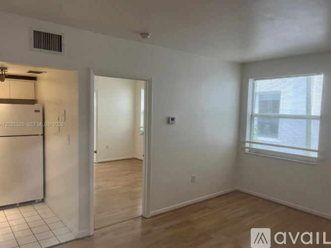 A room with a window and wooden flooring is available for rent.