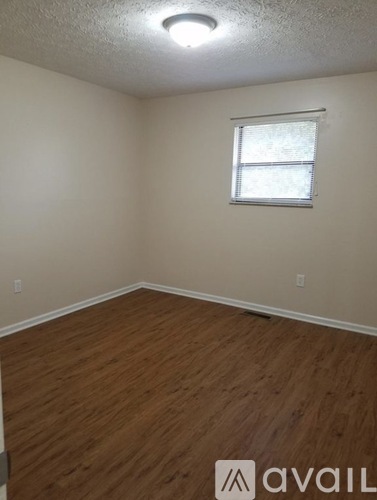 A room with a window and wooden flooring.