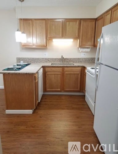 A kitchen with wooden cabinets and a white refrigerator.