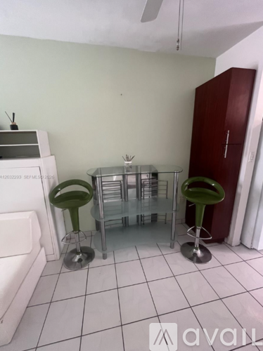 A kitchen with green stools and a red cabinet.