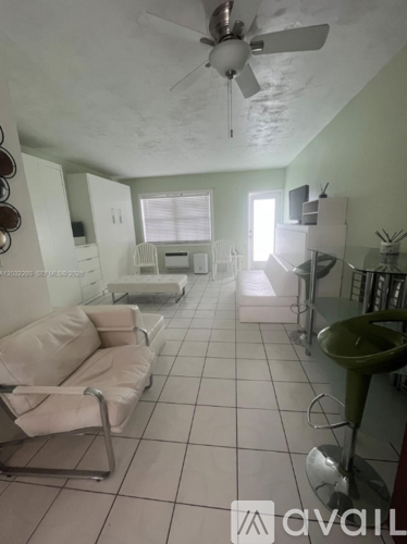 A living room with a white couch and a ceiling fan.