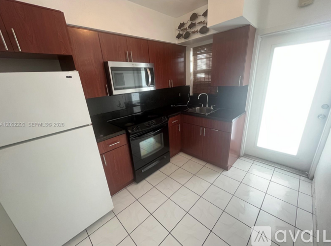 A kitchen with white appliances and brown cabinets.