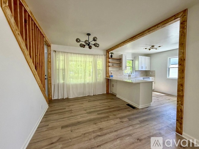 A room with wooden floors and a staircase with wooden railings.