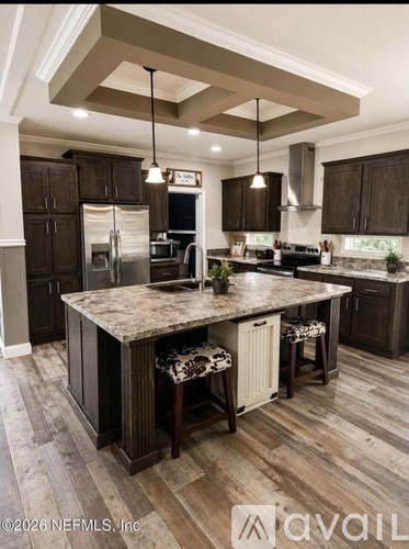 A kitchen with a large island and dark wood cabinets.
