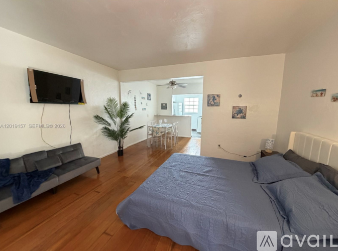 A bedroom with a bed, a couch, and a television.