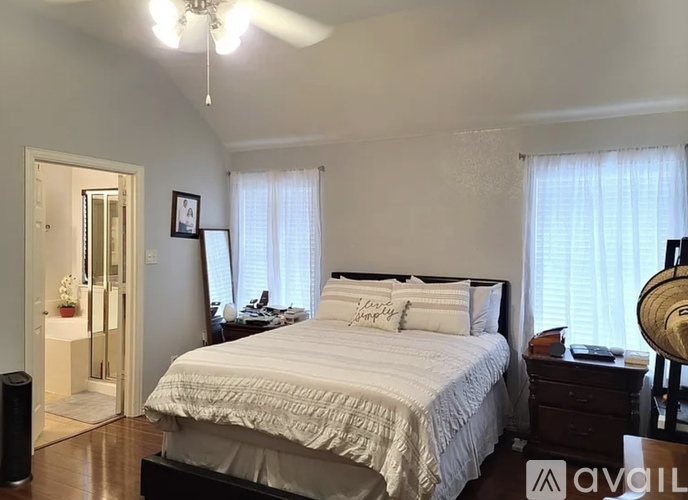 A bedroom with a bed, dresser, and ceiling fan.