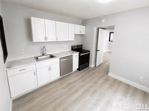 A kitchen with white cabinets and a black oven.