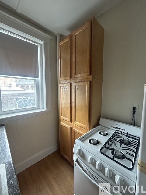 A white gas stove in a kitchen with wooden cabinets.