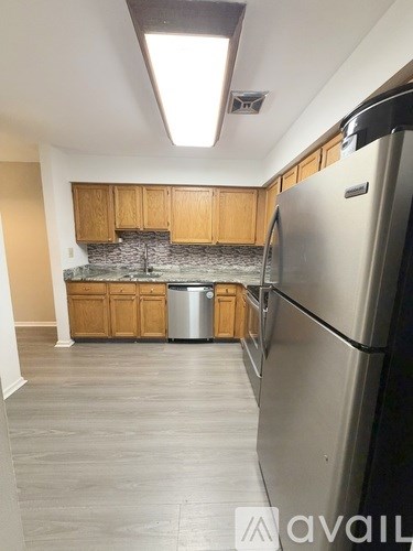 A kitchen with a refrigerator on the right side.