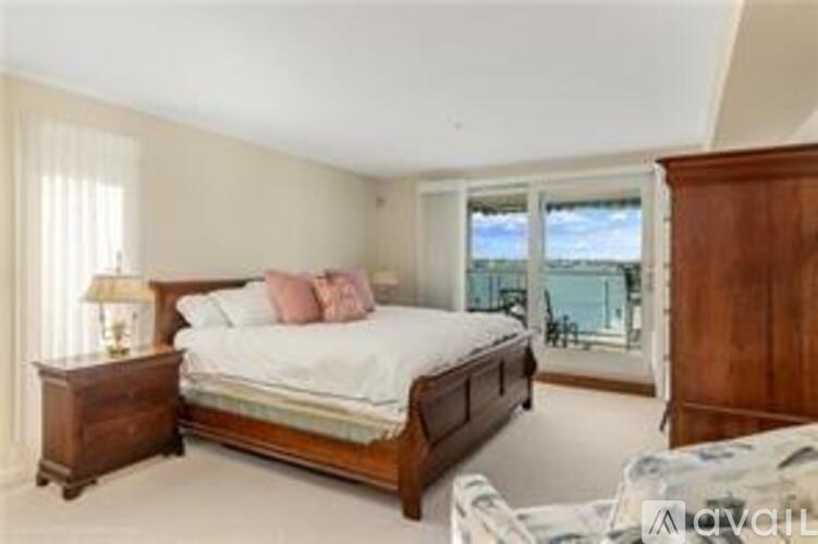 A bedroom with a large bed and a view of the ocean through the window.