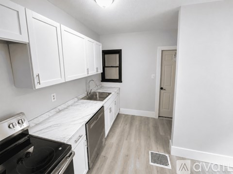 A kitchen with white cabinets and a black stove top oven.