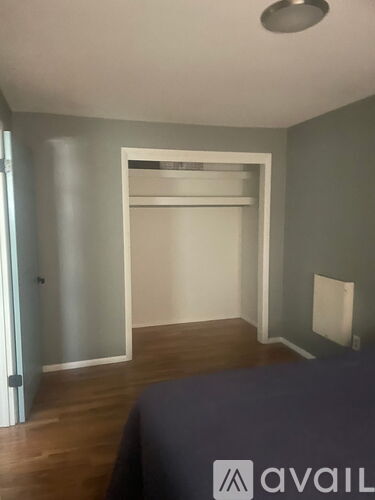 A bedroom with a bed, a wardrobe and a window.