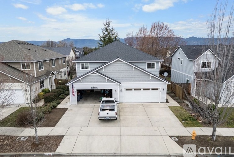 A white car is parked in the driveway of a house with a garage.