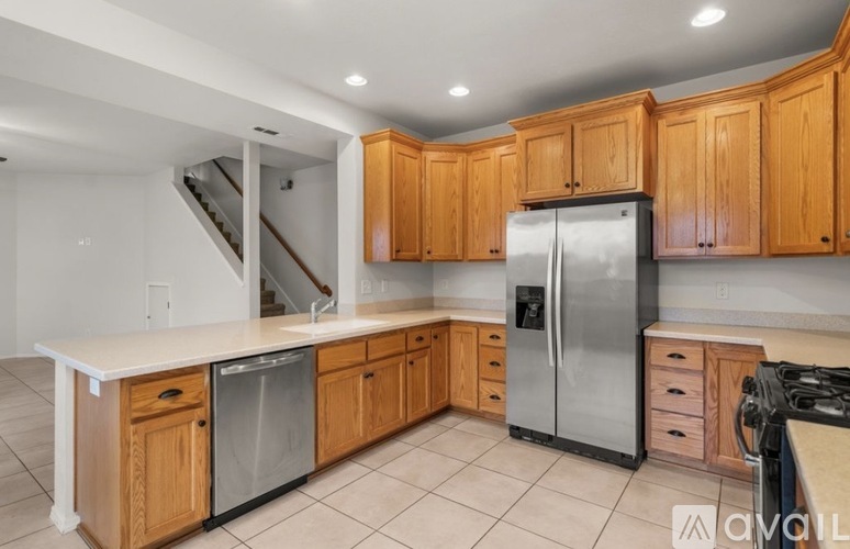 A kitchen with wooden cabinets and a stainless steel refrigerator.