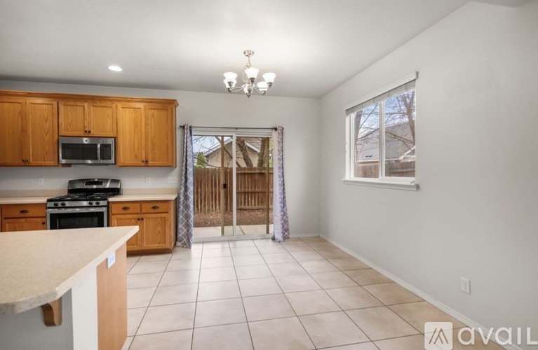 A kitchen with wooden cabinets and a tiled floor.