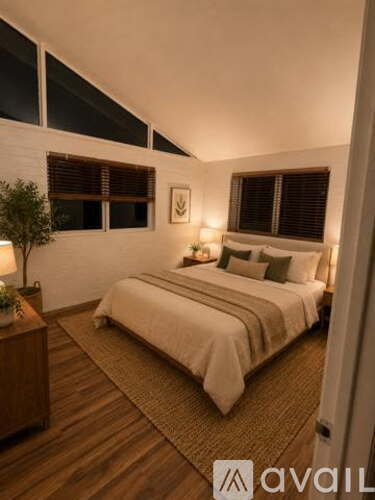 A bedroom with a bed, nightstand, and lamp.