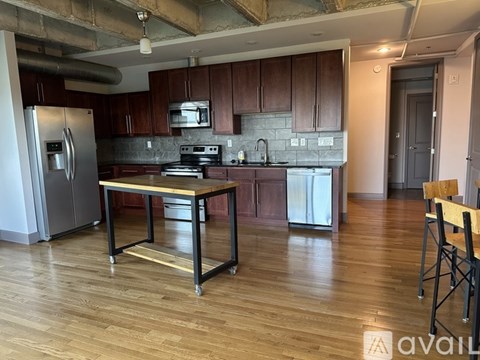A kitchen with wooden cabinets and a stainless steel refrigerator.
