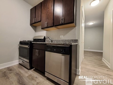 A kitchen with dark brown cabinets and stainless steel appliances.