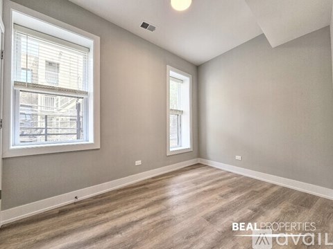A room with a window and a wooden floor.