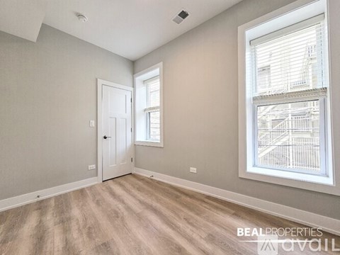 A room with a door and a window with a view of a building outside.