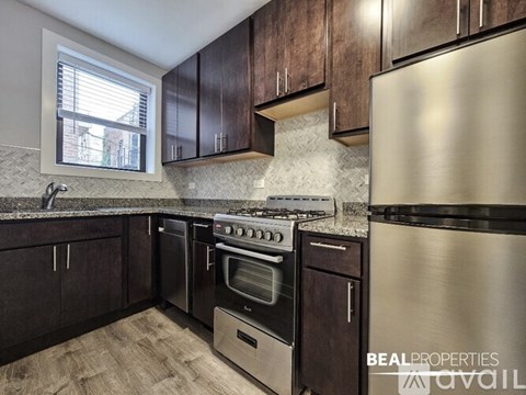 A kitchen with dark wood cabinets and stainless steel appliances is on the market.