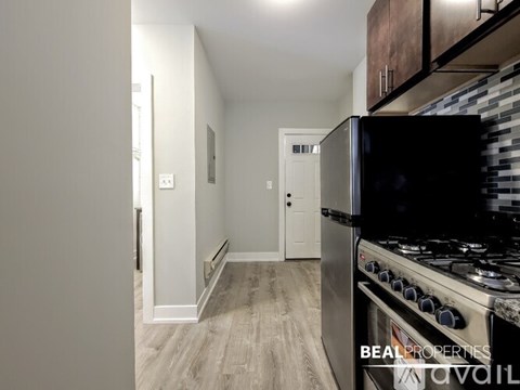 A modern kitchen with a stove and a sign that says "BEAL PROPERTIES AVAILABLE".
