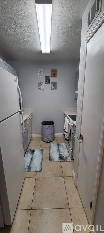 A kitchen with white appliances and a white door.