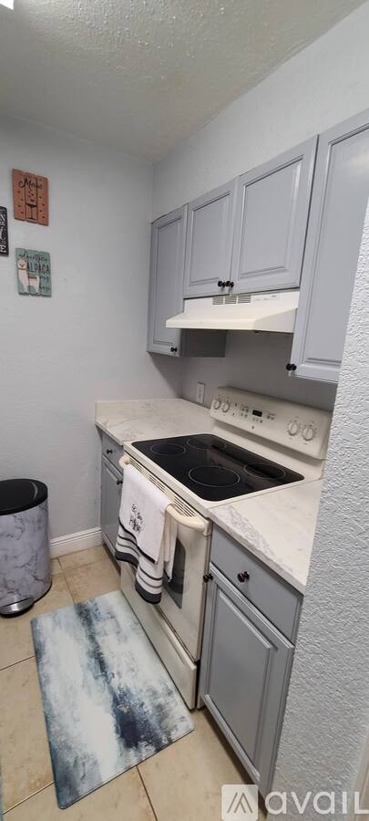 A kitchen with a stove top oven and a white counter top.