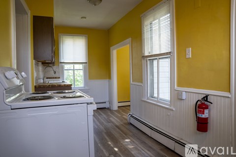 A kitchen with yellow walls and a white stove top oven.