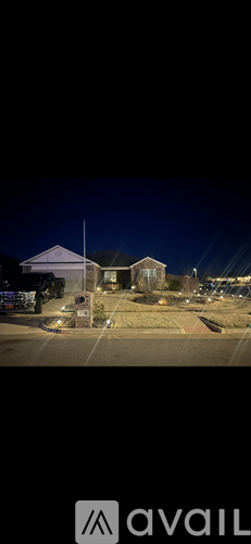 A nighttime view of a building with a lit-up logo that reads "avail".