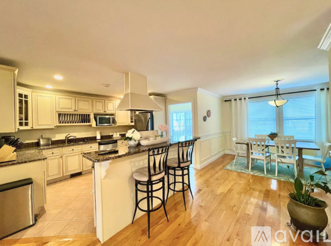 A kitchen with wooden floors and a dining area with a table and chairs.