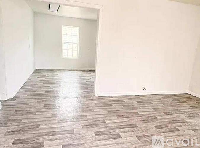 A room with a wooden floor and a window.