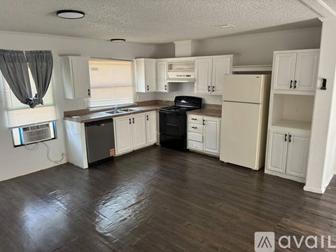 A kitchen with white cabinets and a black stove top oven.