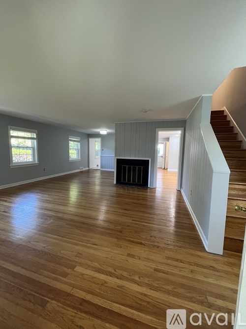 A living room with wood flooring and a staircase.