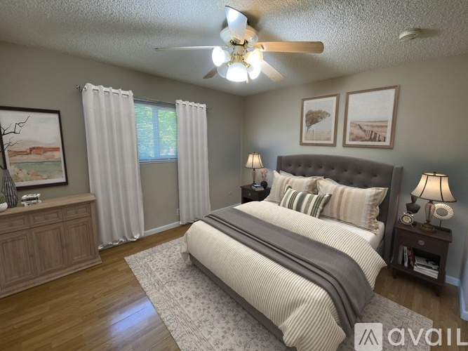 A bedroom with a large bed and a ceiling fan.