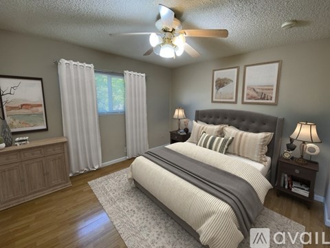 A bedroom with a large bed and a ceiling fan.