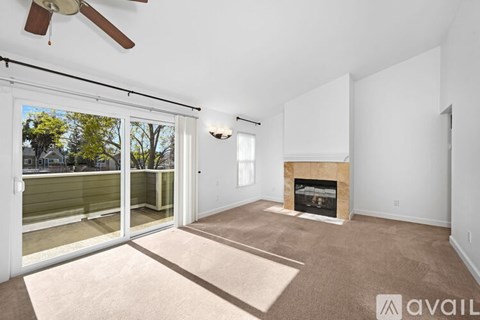 A living room with a fireplace and a fan.