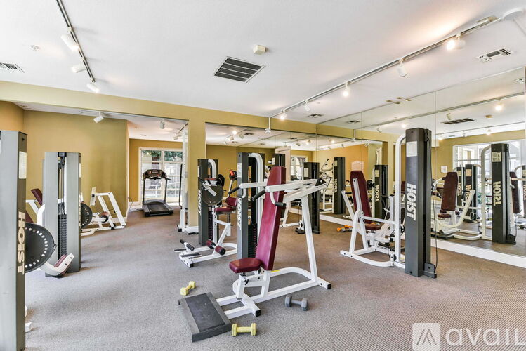 A gym with a variety of equipment including weights and machines.