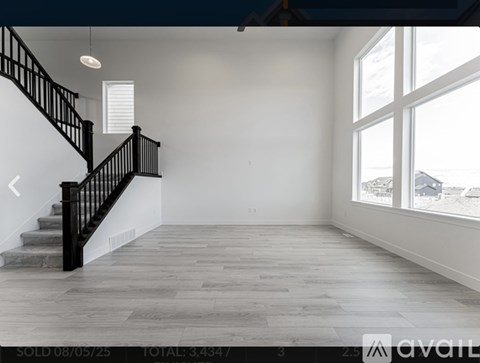 A spacious room with a staircase and large windows.