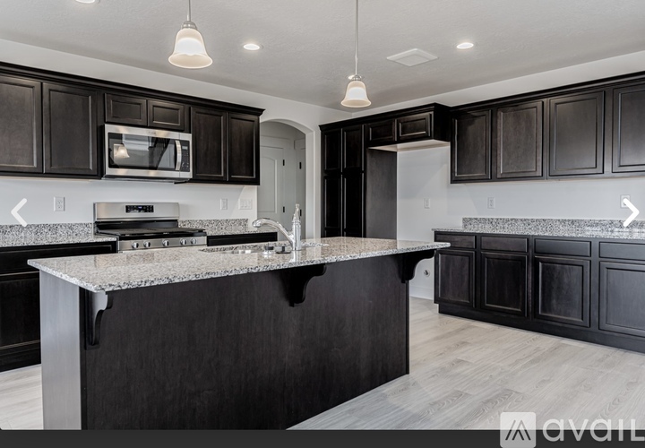 A modern kitchen with dark wood cabinets and a granite countertop.