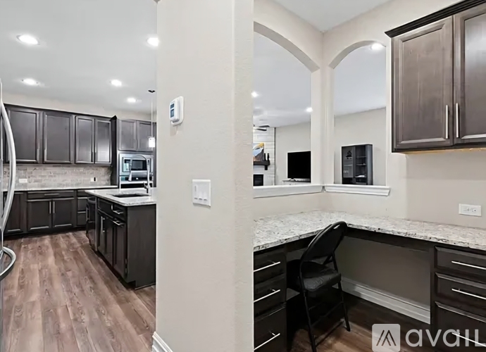 A kitchen with a black chair and a counter top.