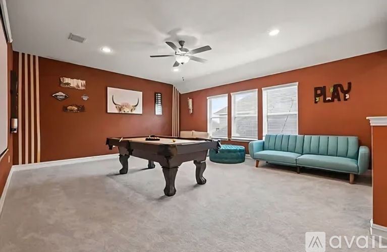 A room with a pool table and a couch.