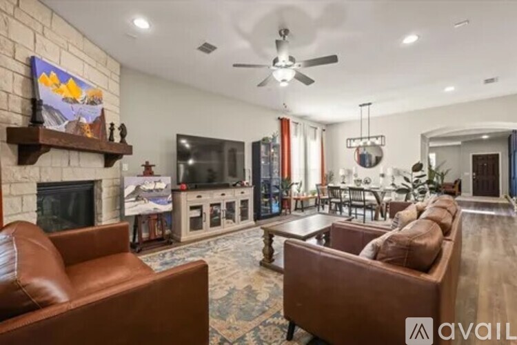 A living room with a brown leather couch and a fireplace.